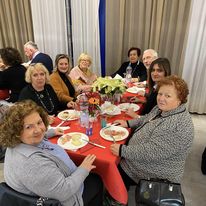 Gruppo di persone sedute a tavola durante una cena conviviale legata alle attività di idrochinesiterapia.