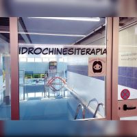 Ingresso di una piscina dedicata all’idrochinesiterapia con area terapeutica attrezzata per riabilitazione motoria ed esercizi in acqua.